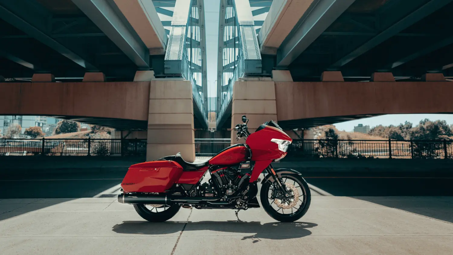 A vibrant red 2025 Harley-Davidson® CVO™ Road Glide® ST rests beneath a bridge in Stuart, Florida.