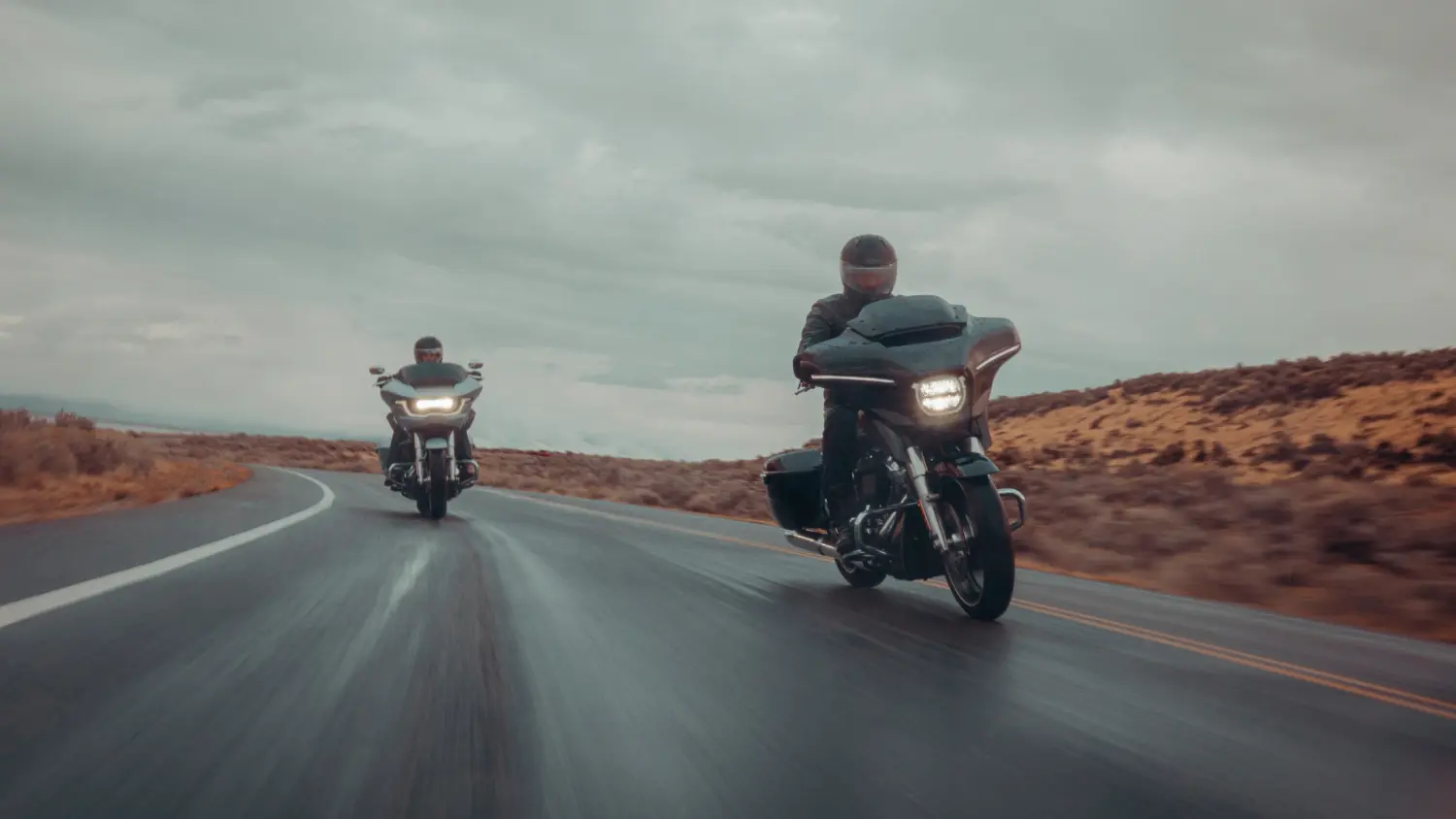 Two riders on 2025 H-D® Grand American Touring Motorcycles cruising down a scenic road in Stuart, FL.