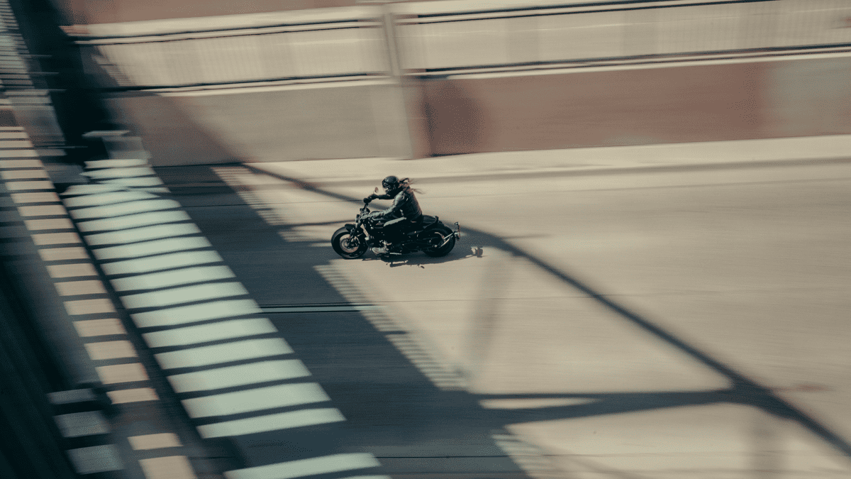 2025 Harley-Davidson® Sport motorcycle speeding through a city overpass, captured with a motion blur effect to emphasize performance and agility.