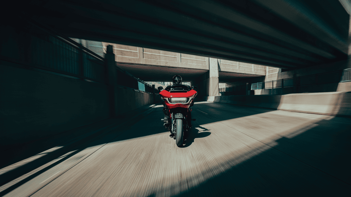 Front view of a red 2025 Harley-Davidson® CVO™ Road Glide® ST riding through an urban underpass near Sanford, FL.