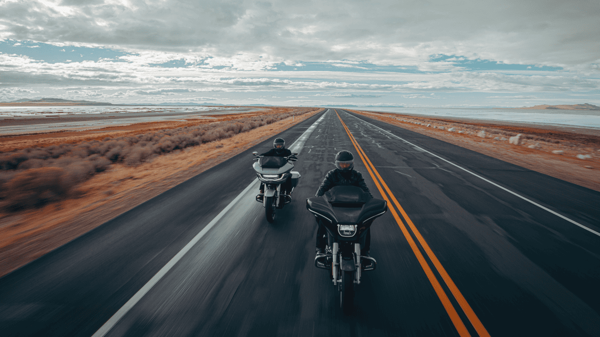 Two 2025 Harley-Davidson® touring bikes riding side by side on an open highway, representing top model picks for Orlando road trips.