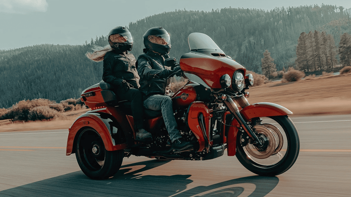 2025 Harley-Davidson® Tri Glide® Ultra in striking red cruising with two riders through the open roads near Central Florida.