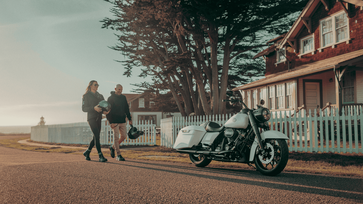 Couple enjoying a scenic weekend stop with the 2025 Harley-Davidson® Road King® Special parked near a cottage in Sanford, FL.