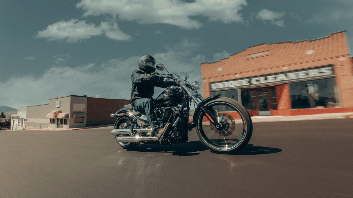 Rider leans into a turn on the 2025 Harley-Davidson® Breakout® near Sanford, FL, with chrome details and a long, low-slung stance on display.