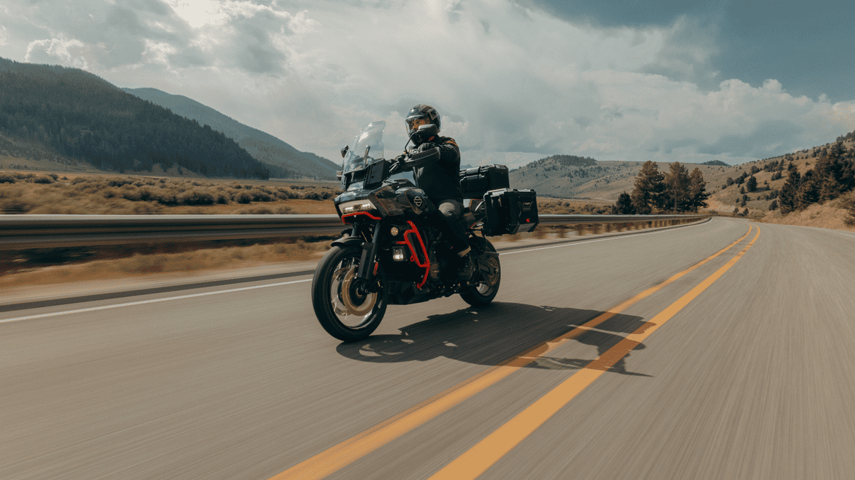 Rider takes the 2025 Harley-Davidson® CVO™ Pan America® on a scenic mountain road near Sanford, FL, showcasing its adventure touring setup and storage packs.