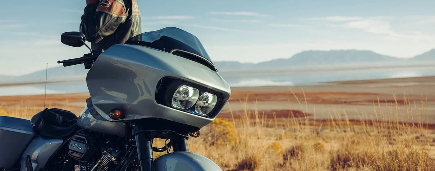A grey 2023 Harley-Davidson Road Glide is shown from the side while parked after leaving a dealer th…