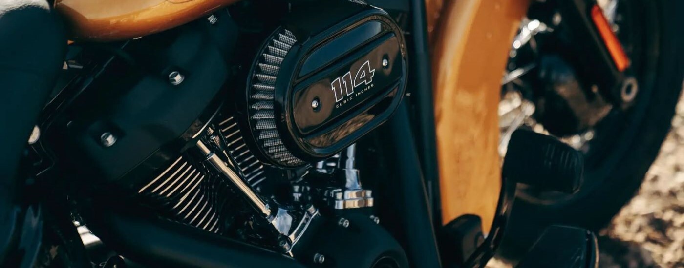 A close up shows the engine on a yellow 2023 Harley-Davidson Heritage Classic after leaving a motorc…