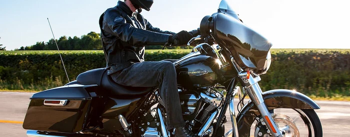 A close up shows a person riding a 2022 Harley-Davidson Street Glide for sale.
