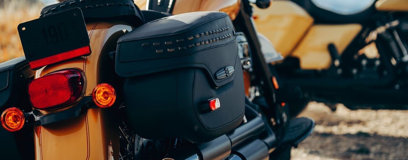 A close up shows the black leather bag on a yellow 2023 Harley-Davidson Heritage Classic.