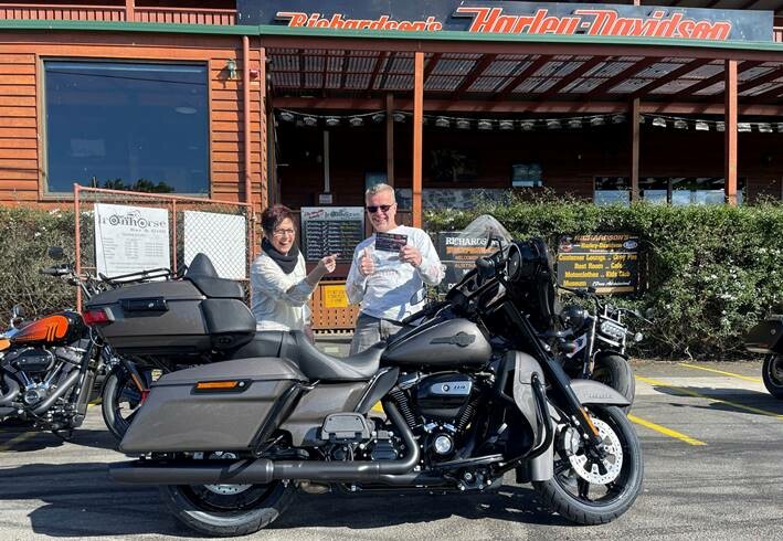 May be an image of 2 people, motorcycle, road and text