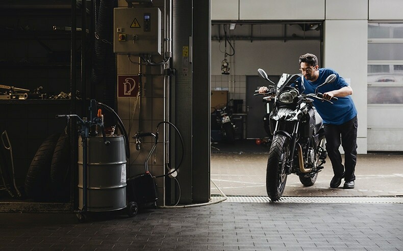 BMW engineer moving motorcycle into garage