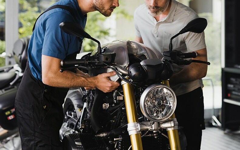 Two men inspecting a motorcycle