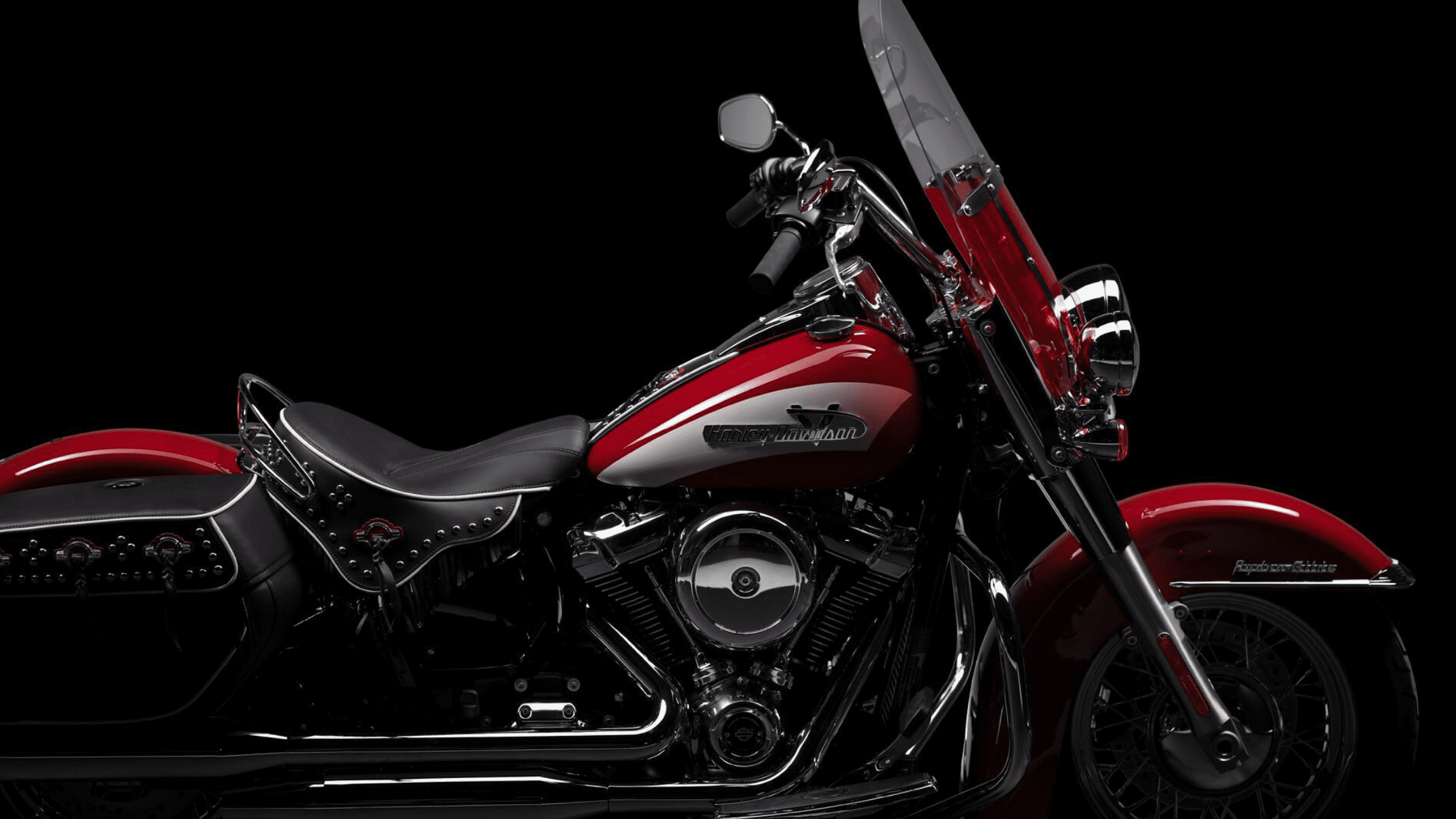 A red motorcycle showcased on a black background, accentuating its sleek lines and dynamic presence in the image.