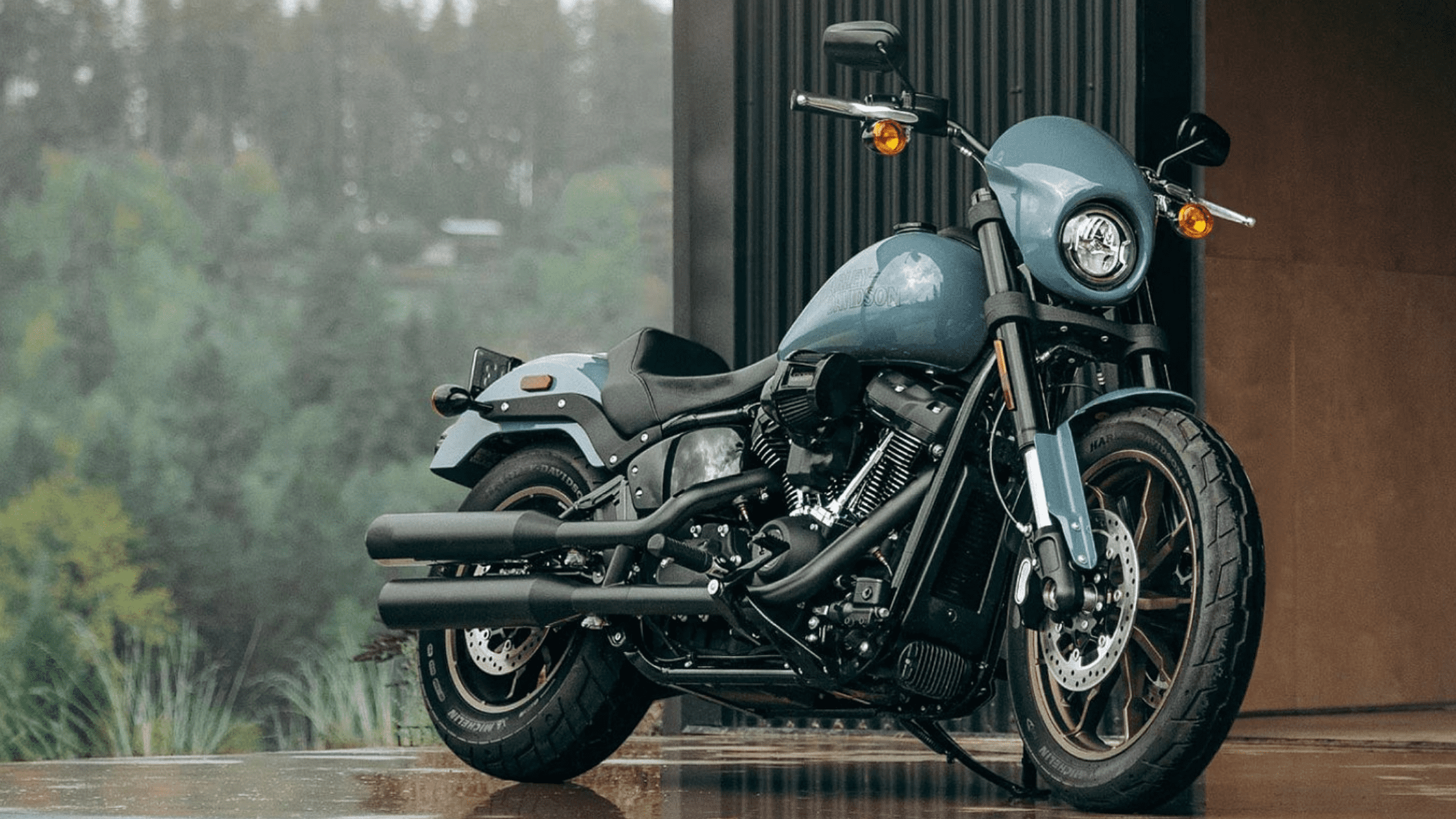 A 2024 Harley-Davidson® Low Rider® S parked in front of a building, featuring a sleek blue finish and blacked-out components