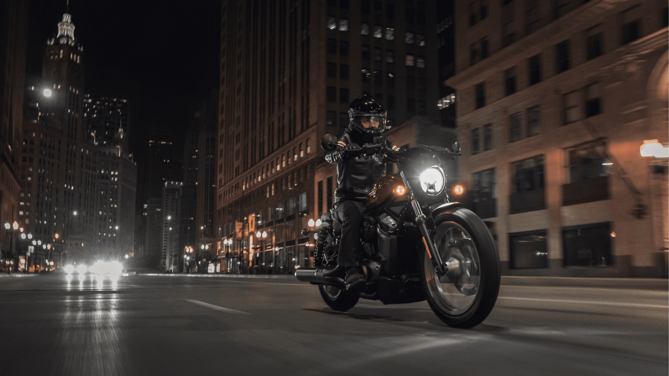Motorcyclist riding a 2024 Harley-Davidson® Nightster® Special through a city street at night in Rogers, AR, showcasing the bike's sleek design and powerful performance under city lights.
