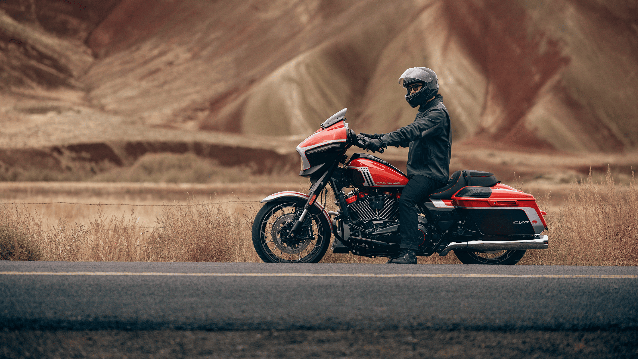 Rider on a 2024 Harley-Davidson® CVO™ Street Glide® cruising through scenic landscapes near Bentonville, highlighting the motorcycle's performance and sleek design.