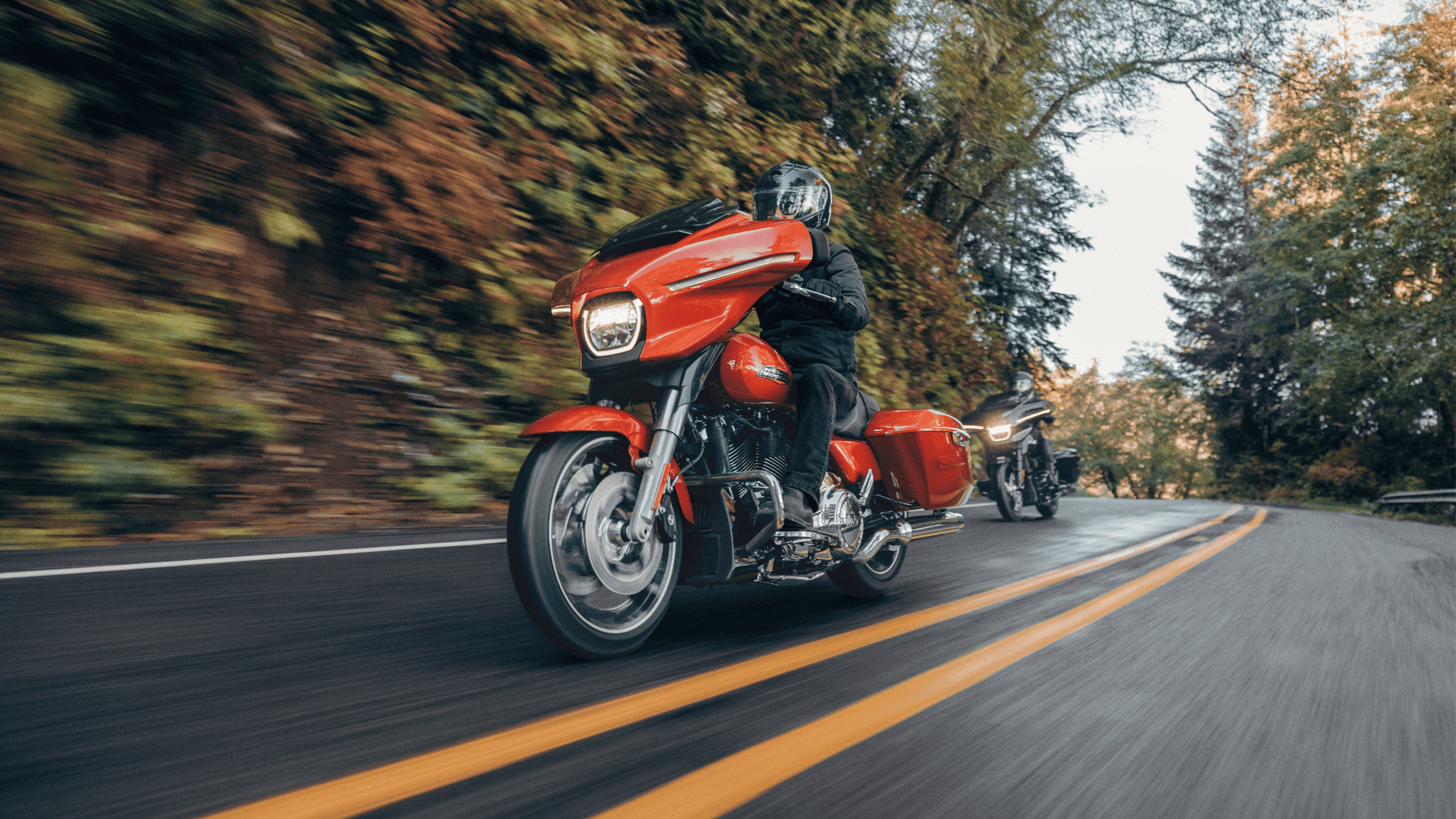 2024 Harley-Davidson® Street Glide® leading a group ride through scenic roads, showcasing its iconic style and performance.