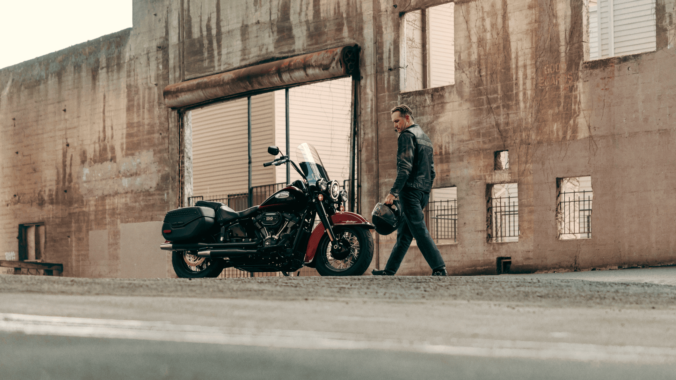 2024 Harley-Davidson® Heritage Classic parked by an urban building, showcasing timeless style and power.