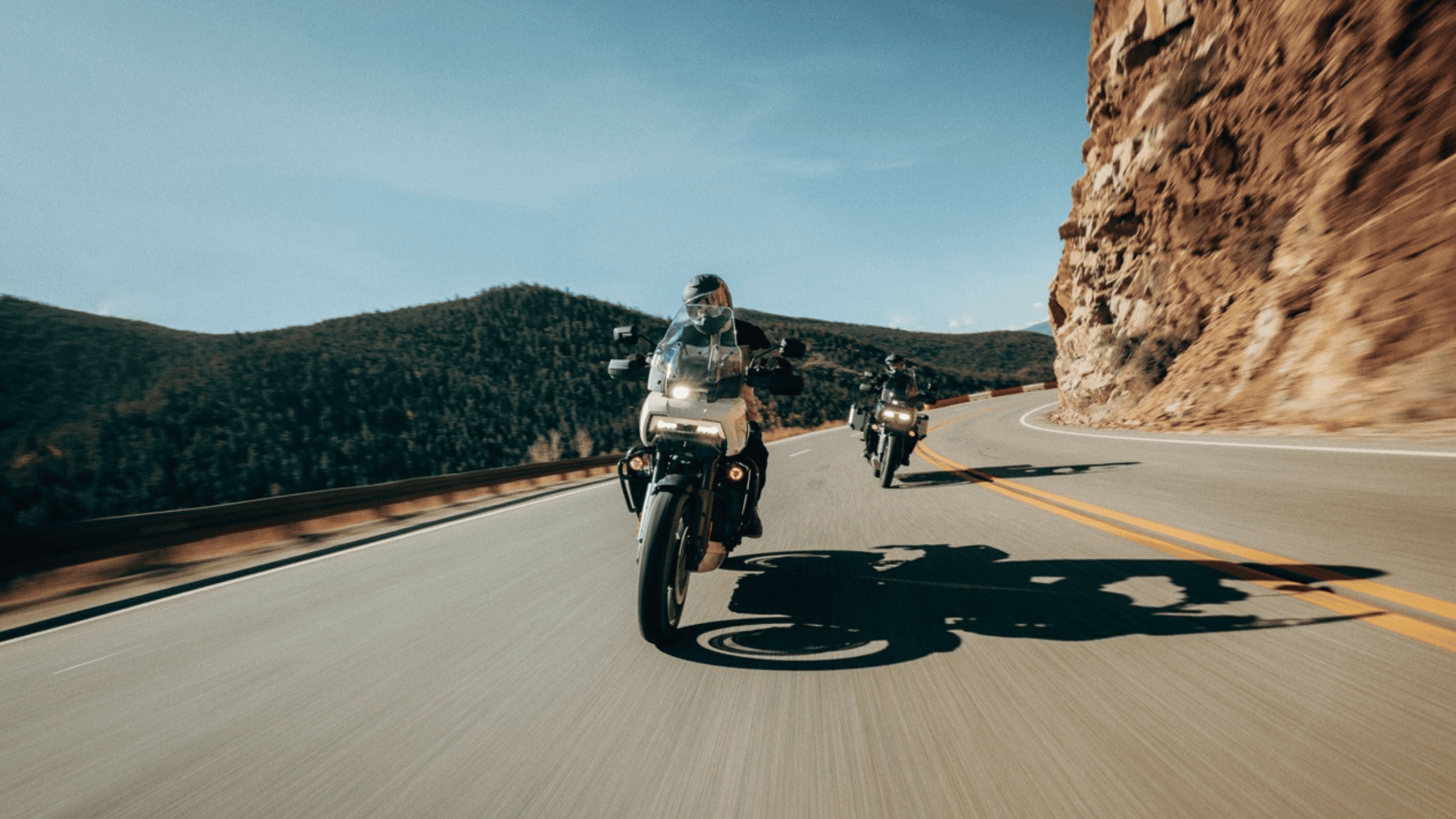 Two riders on 2024 Harley-Davidson® Pan America® 1250 Special motorcycles on a curving mountain road