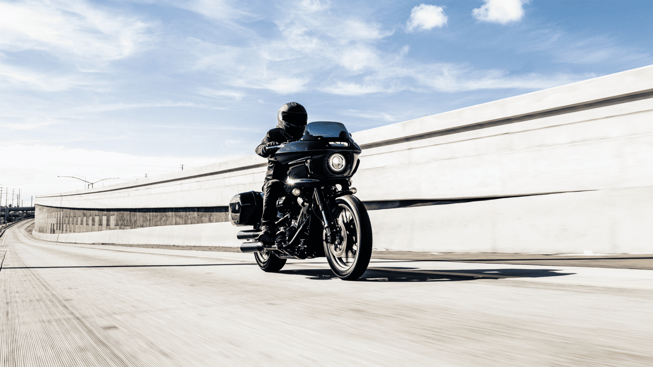 2024 Harley-Davidson® Low Rider® ST on open highway, rider in black gear.