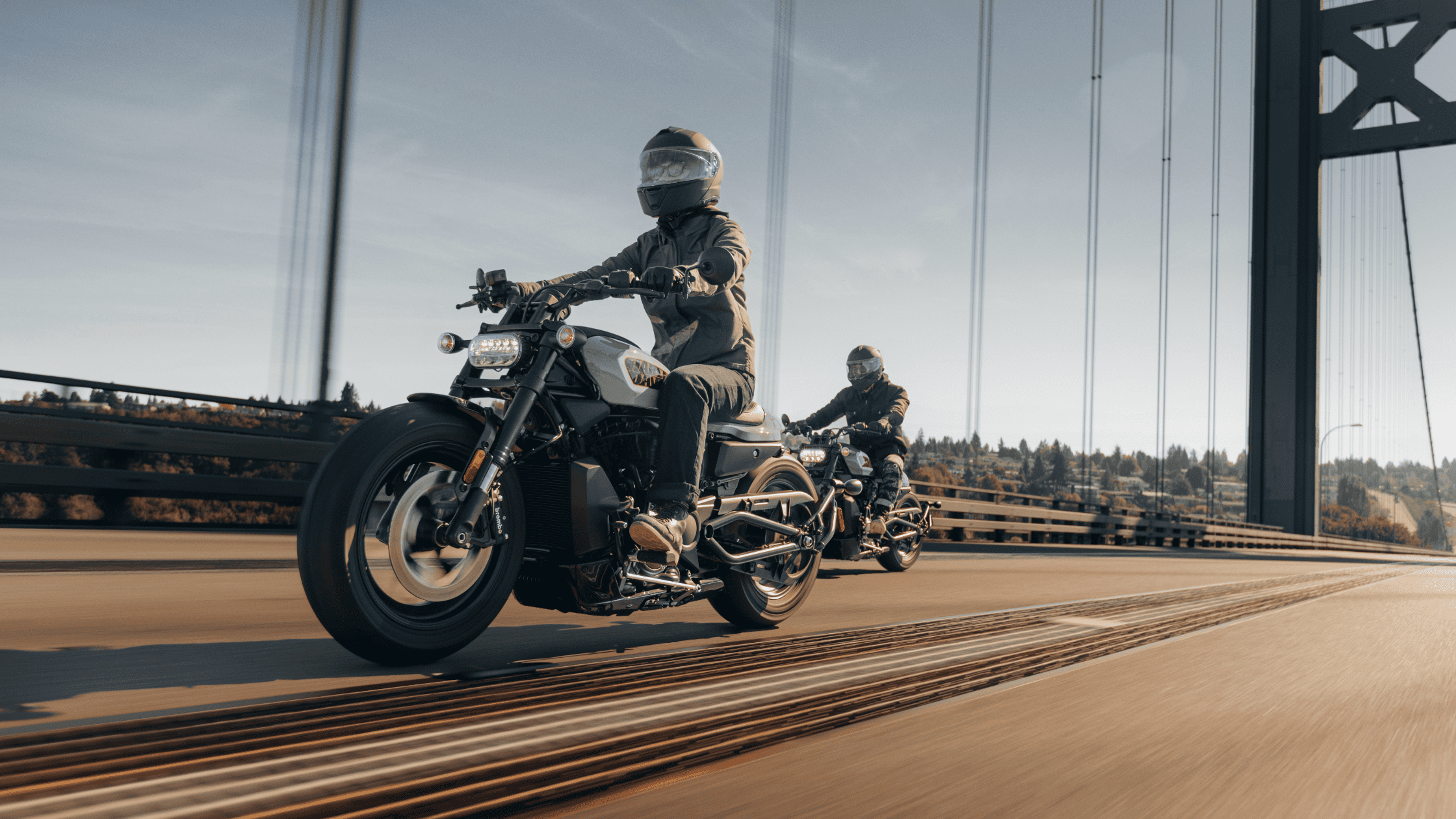 2024 Harley-Davidson® Sportster® S riders crossing bridge, scenic background.