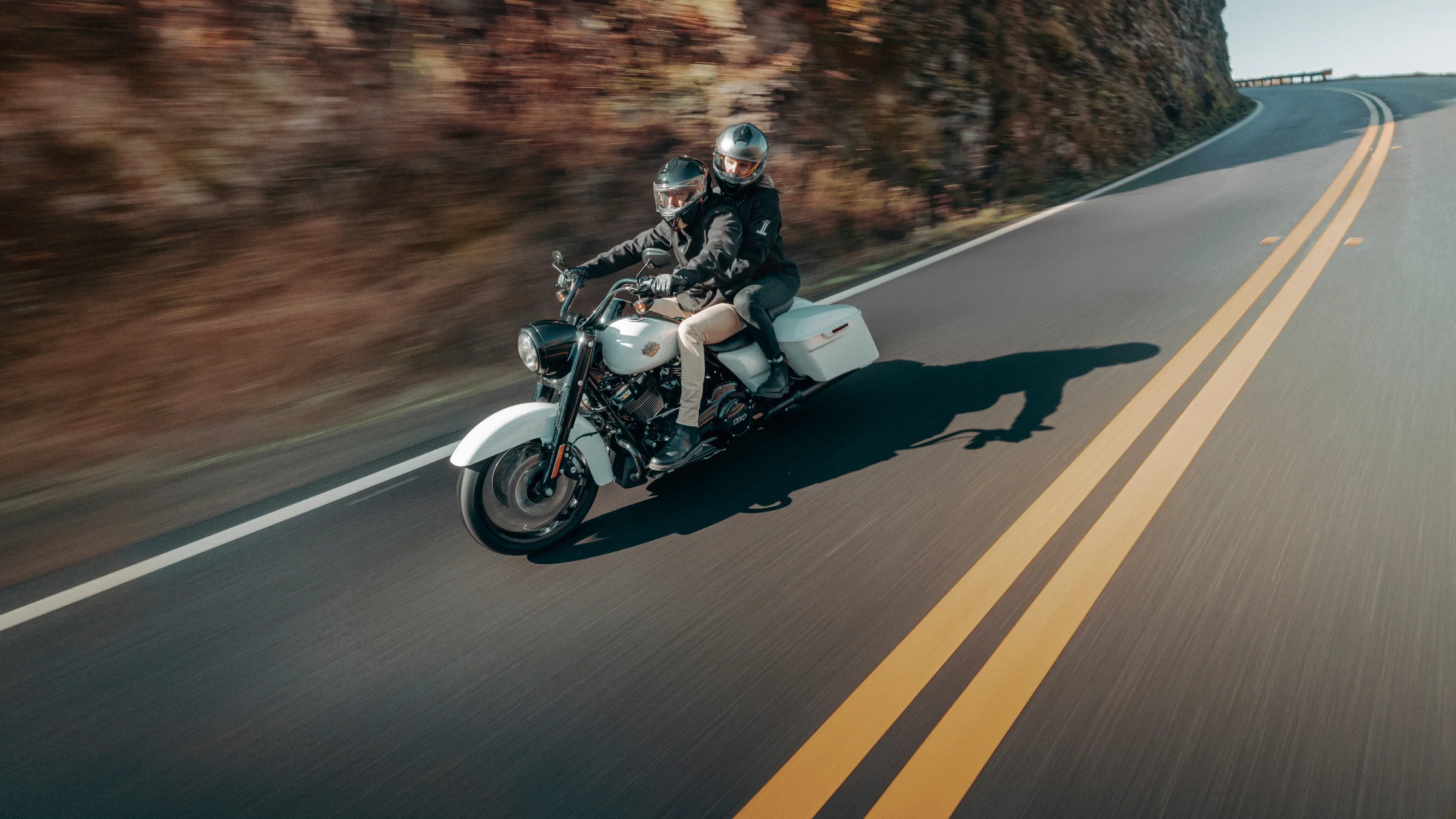 Two riders on a Harley-Davidson Road King® Special cruising on open road.