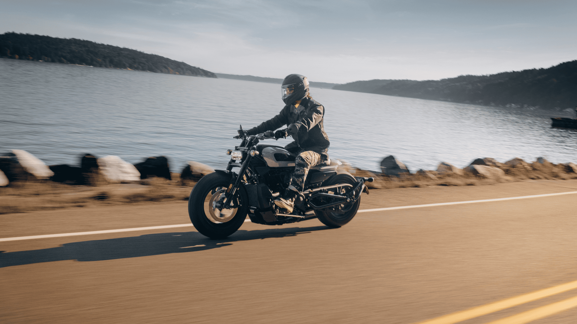 Harley-Davidson Low Rider® S parked near industrial silos, highlighting its rugged design in an urban setting.