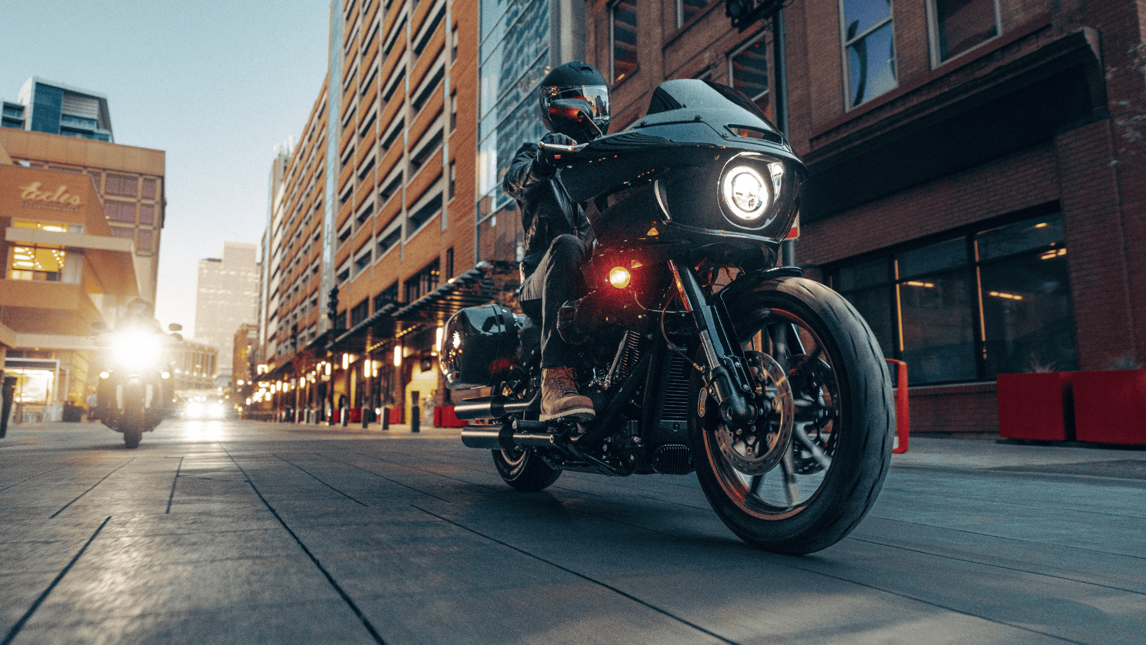 Motorcycle cruising through city streets at twilight.