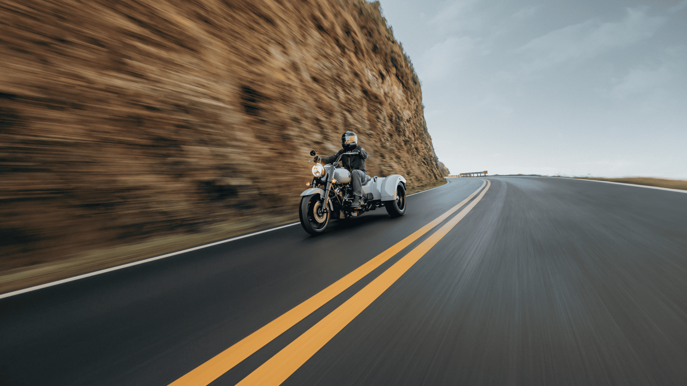 2024 Harley-Davidson® Freewheeler® cruising on a winding highway, showcasing its sleek design and freedom-inspiring performance