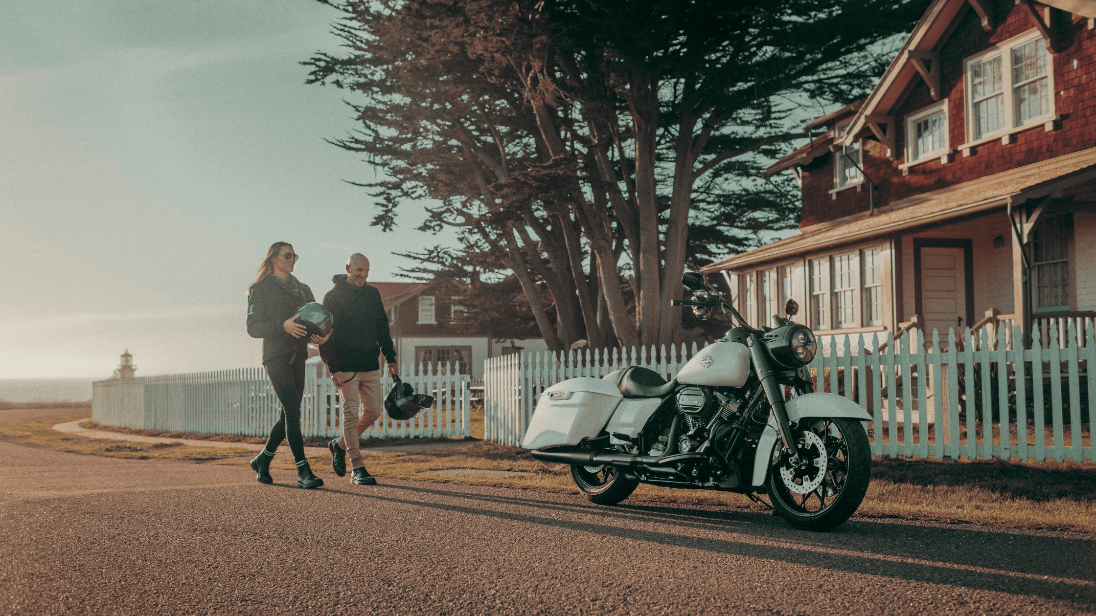 A couple walking toward a parked 2024 Harley-Davidson® Road King® Special near Bentonville, AR, highlighting the bike's sleek design and touring features.