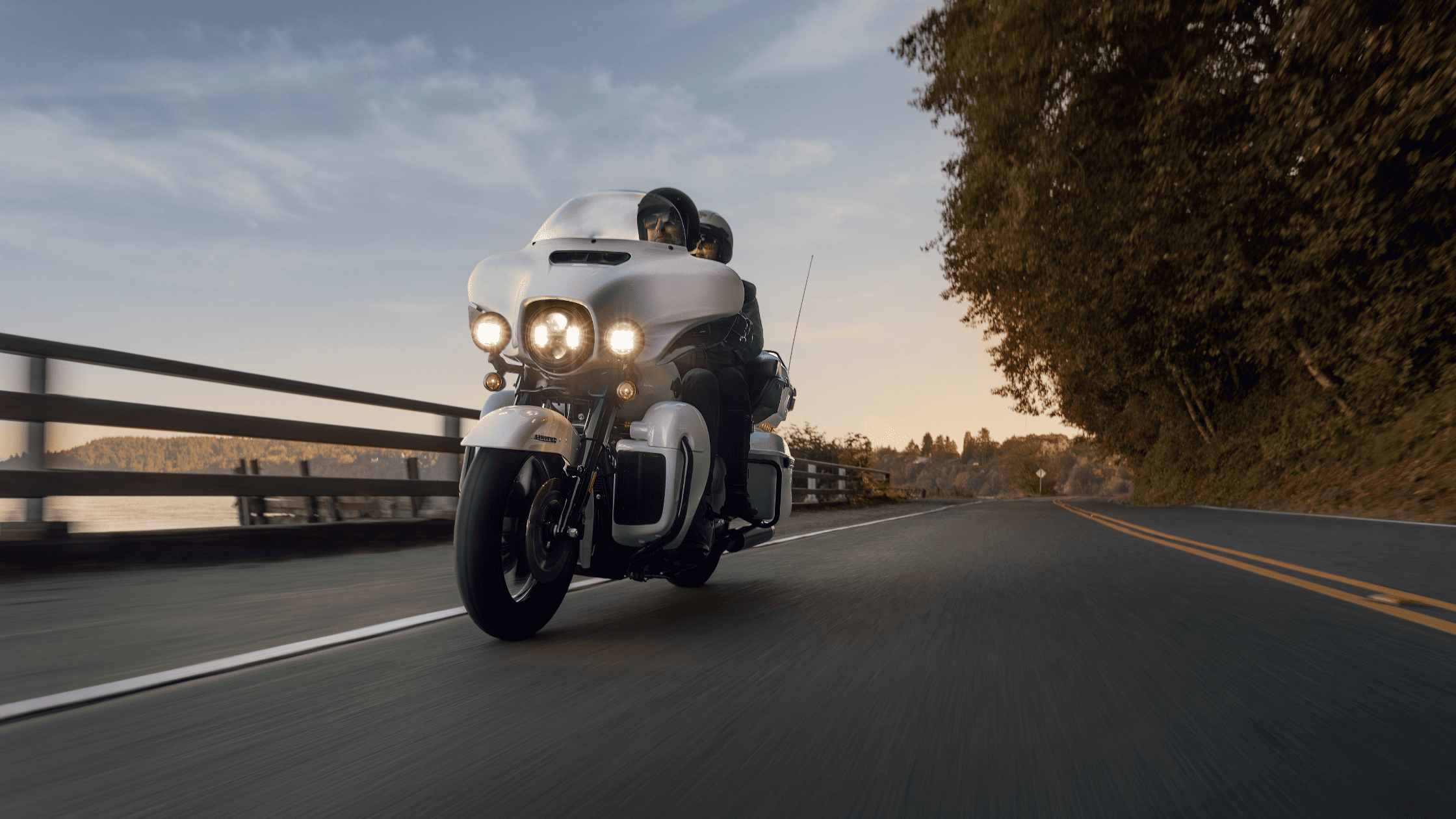 A rider on a 2024 Harley-Davidson® Ultra Limited® motorcycle cruising along a scenic road