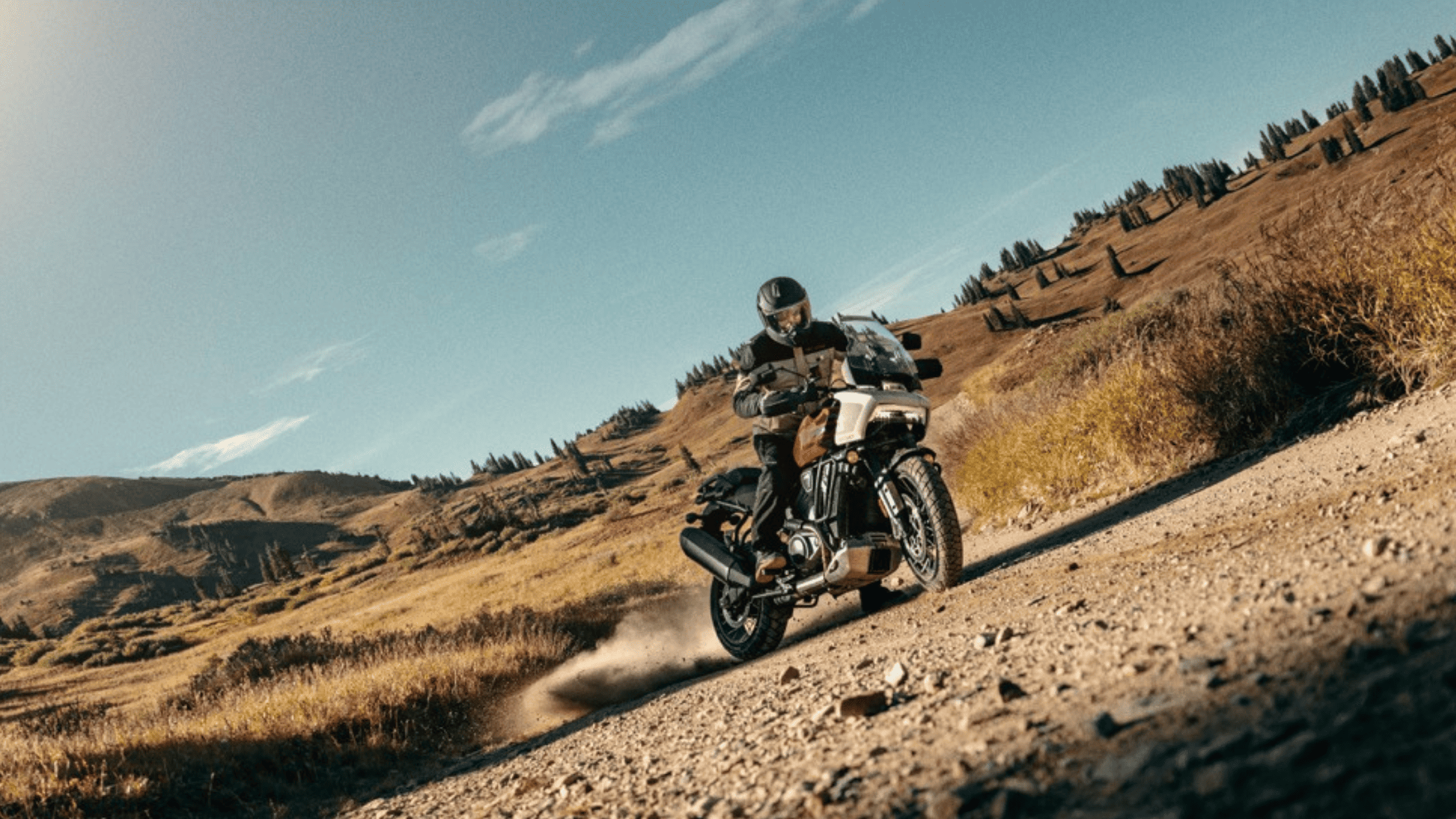 A motorcyclist navigates a dirt road, showcasing skill and adventure amidst a natural landscape.
