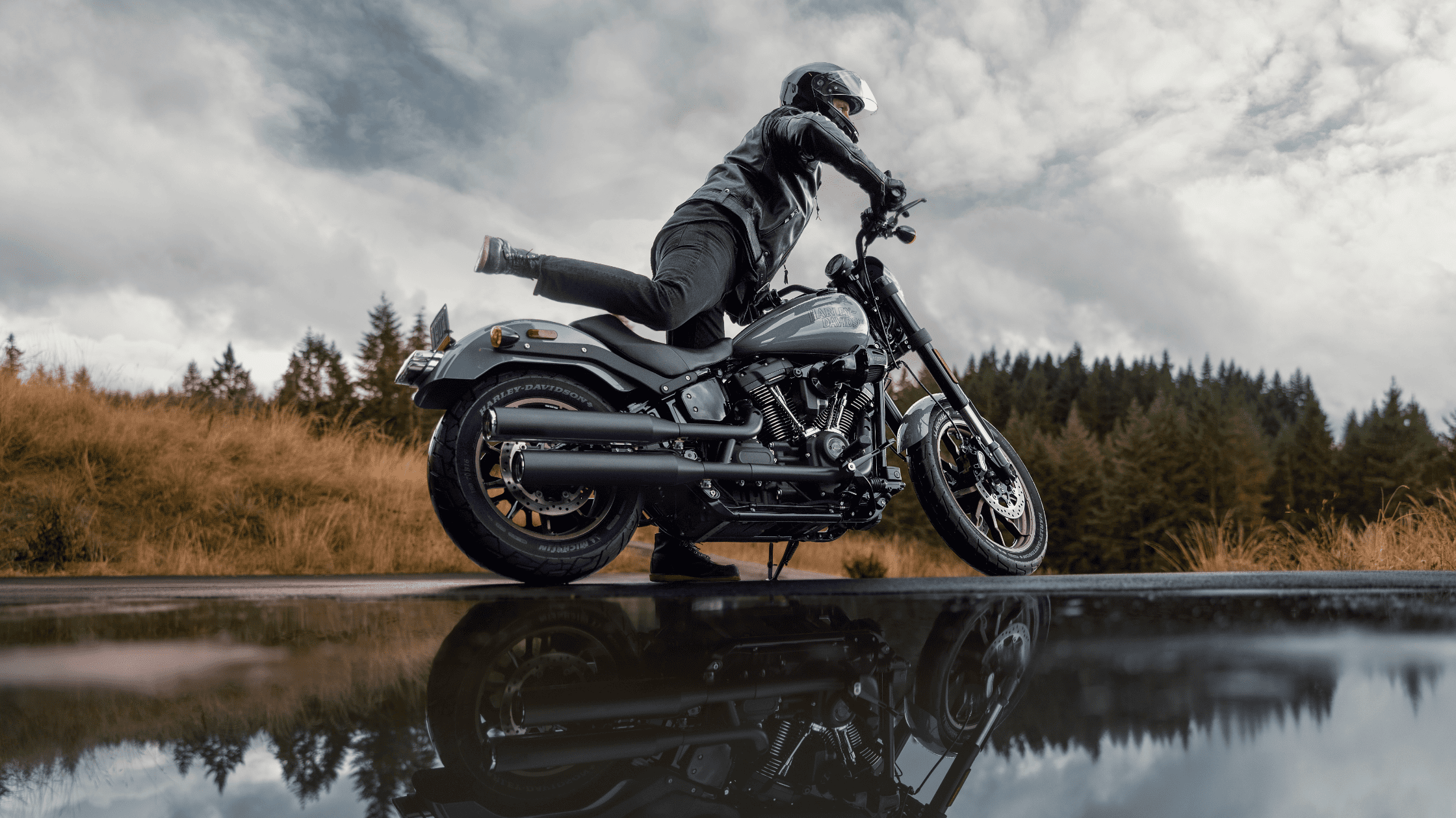 A man rides a 2024 Harley-Davidson® Low Rider® S motorcycle on a slick, wet road, showcasing skill and confidence