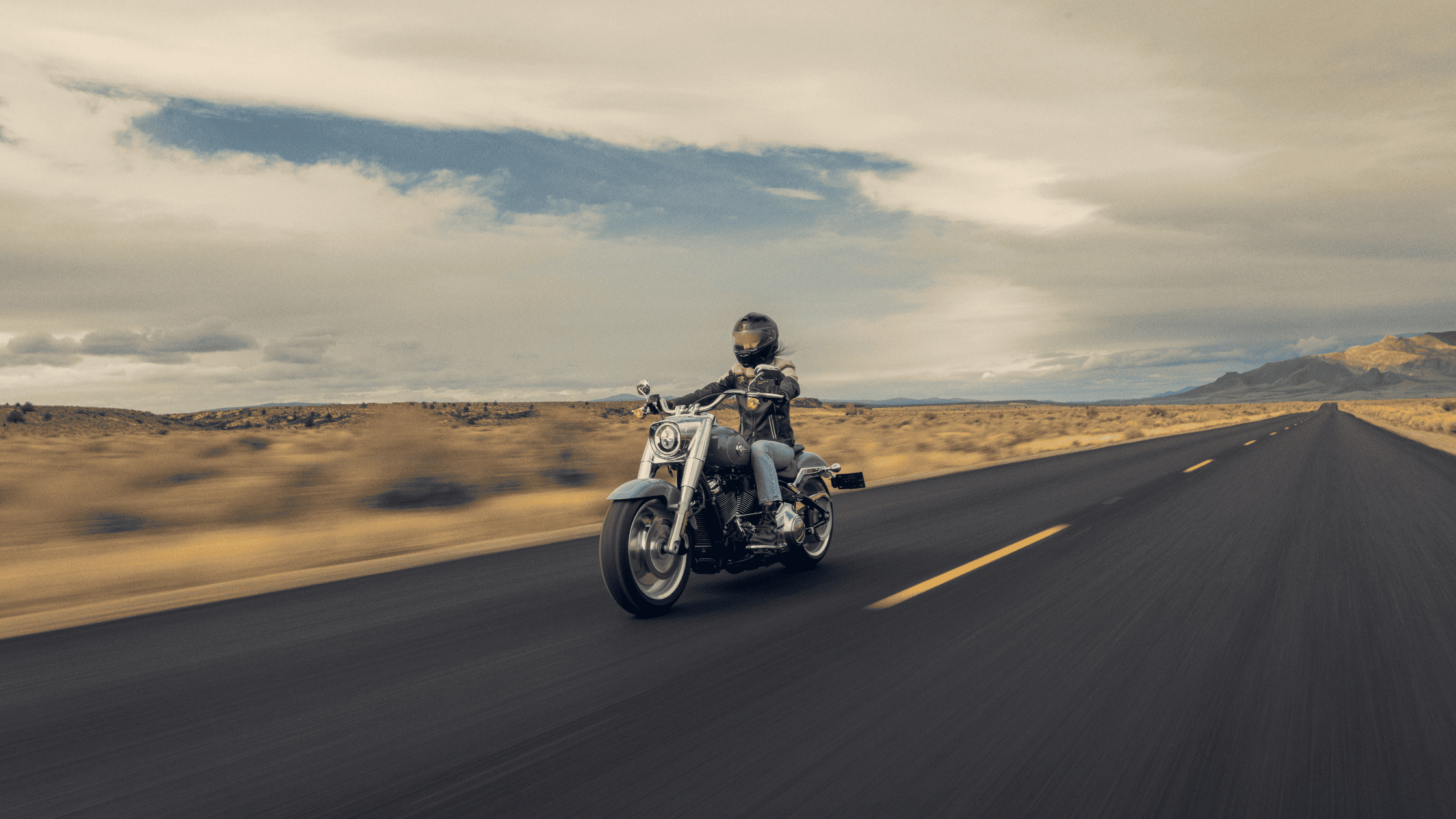 A man rides a 2024 Harley-Davidson® Low Rider® S motorcycle on a slick, wet road, showcasing skill and confidence