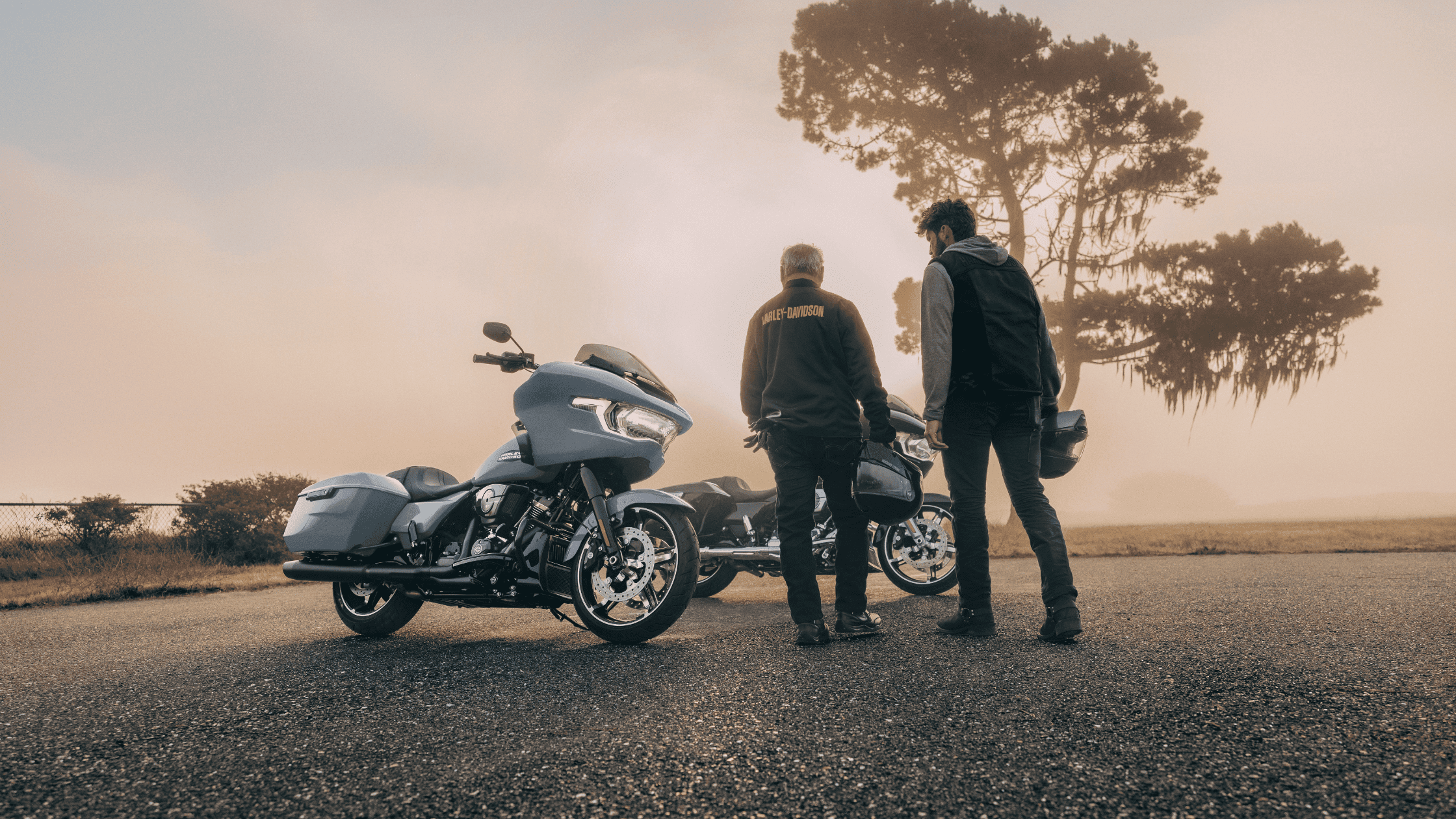 Foggy landscape with two 2024 Harley-Davidson® Road Glide® bikes and riders ready for a morning ride