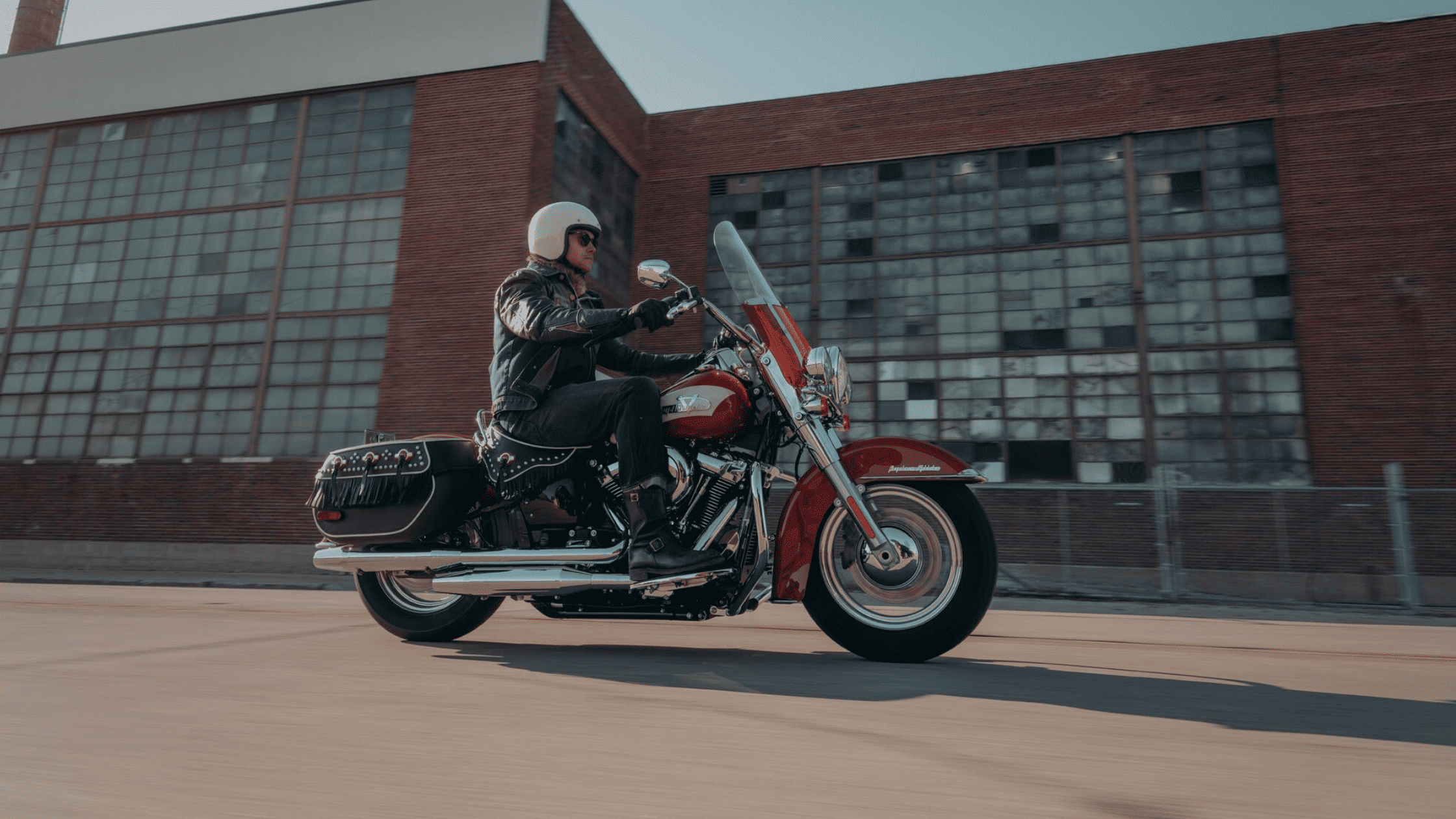 Motorcycle rider passing by a building