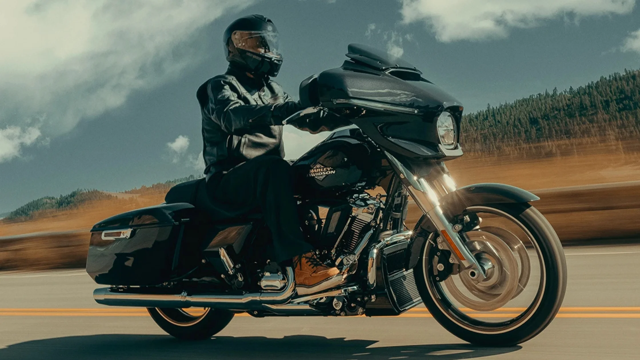 Rider cruising on a 2025 Harley-Davidson Street Glide on a scenic open road.