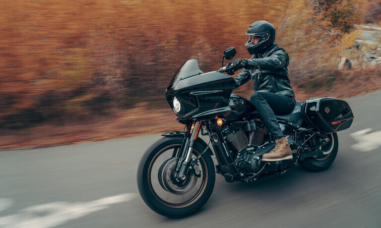 2024 Harley-Davidson Low Rider ST riding past bushes