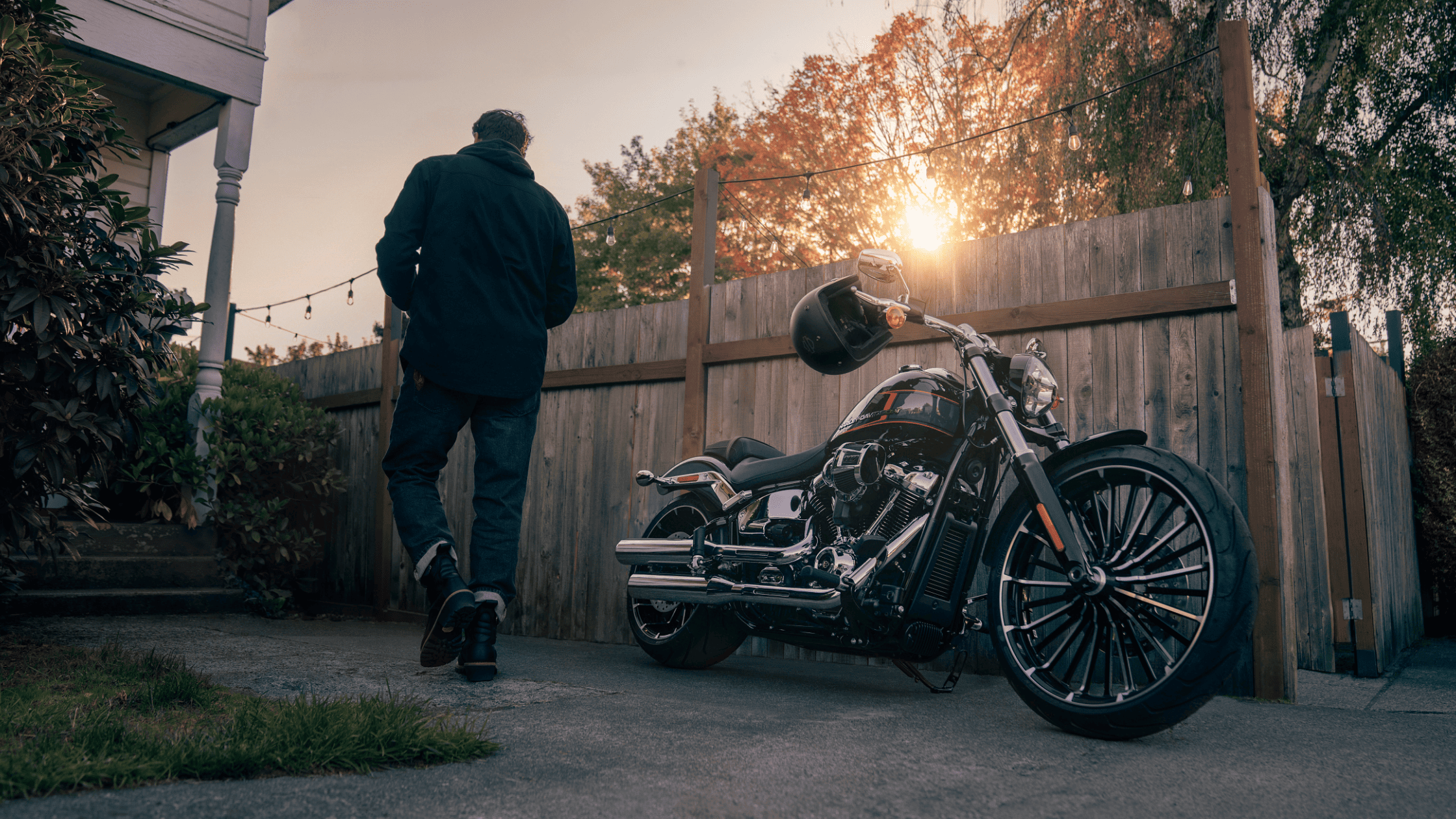 A man strolls by a parked 2024 Harley-Davidson® Breakout® 117 in a driveway, highlighting the motorcycle's impressive features.