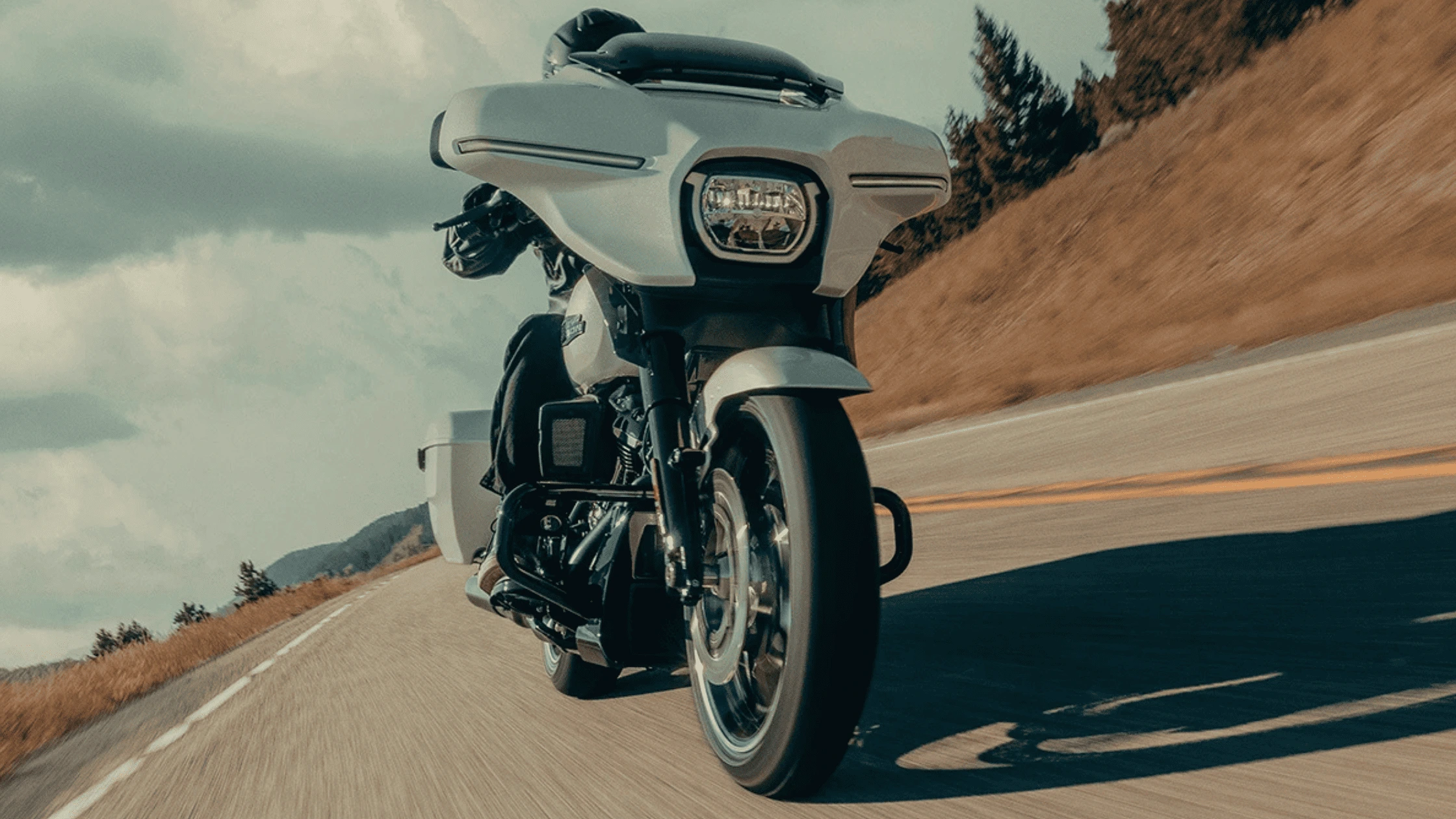 The 2025 Harley-Davidson® Street Glide® on a winding open road, showcasing a blend of versatility, comfort, and touring performance.