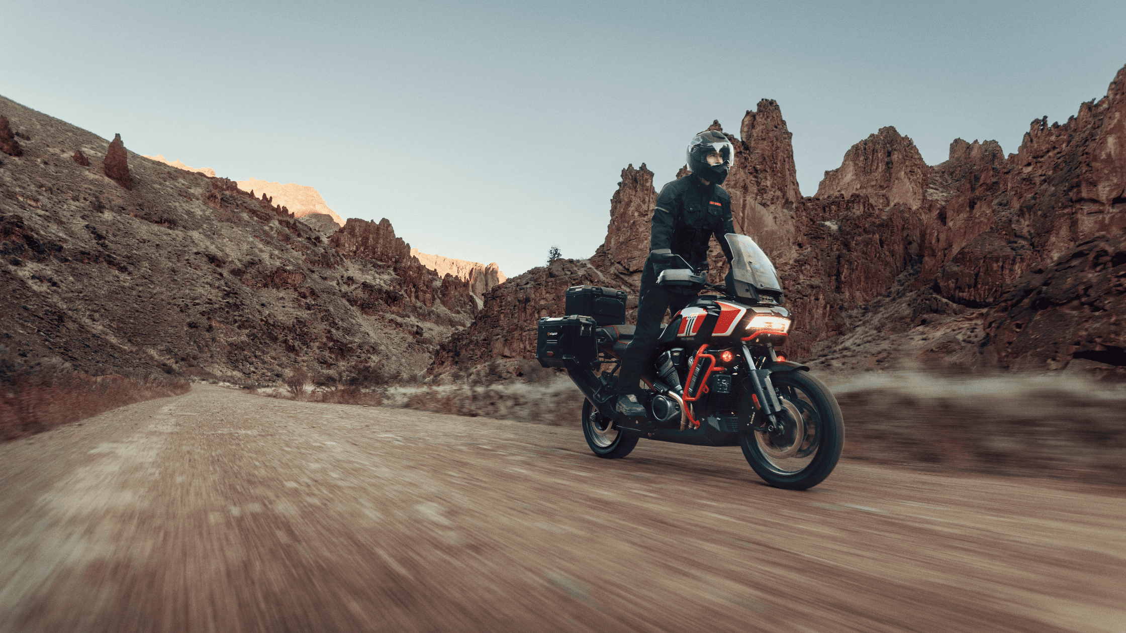 A 2024 Harley-Davidson® CVO™ Pan America® adventure motorcycle riding through rugged desert terrain