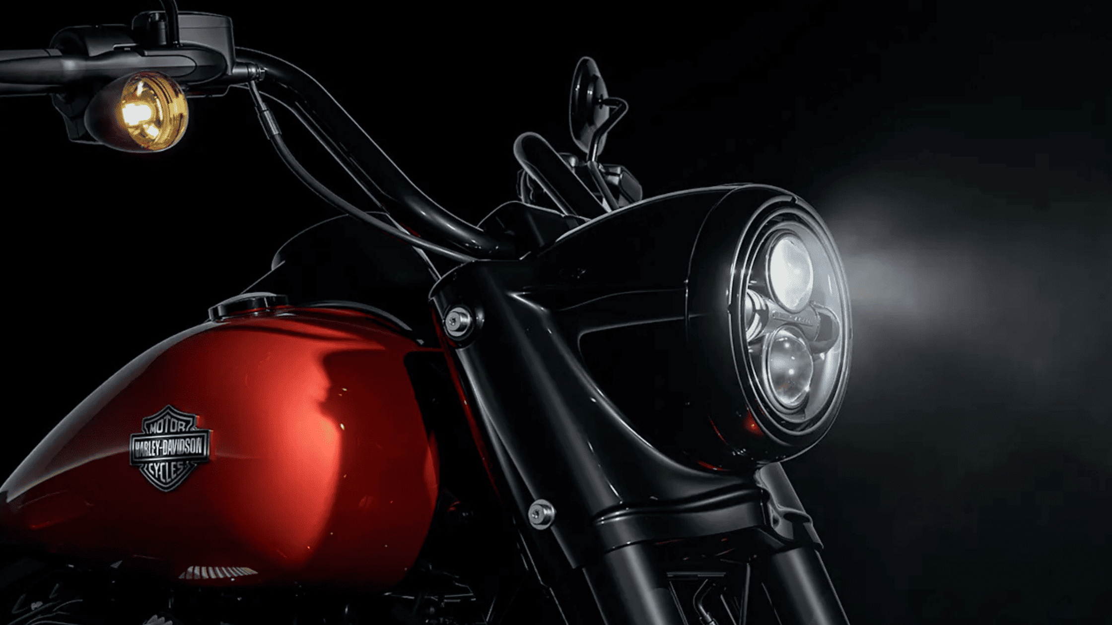 Close-up of a 2025 Harley-Davidson® Road King® Special motorcycle with its headlight illuminated, showcasing its sleek design.