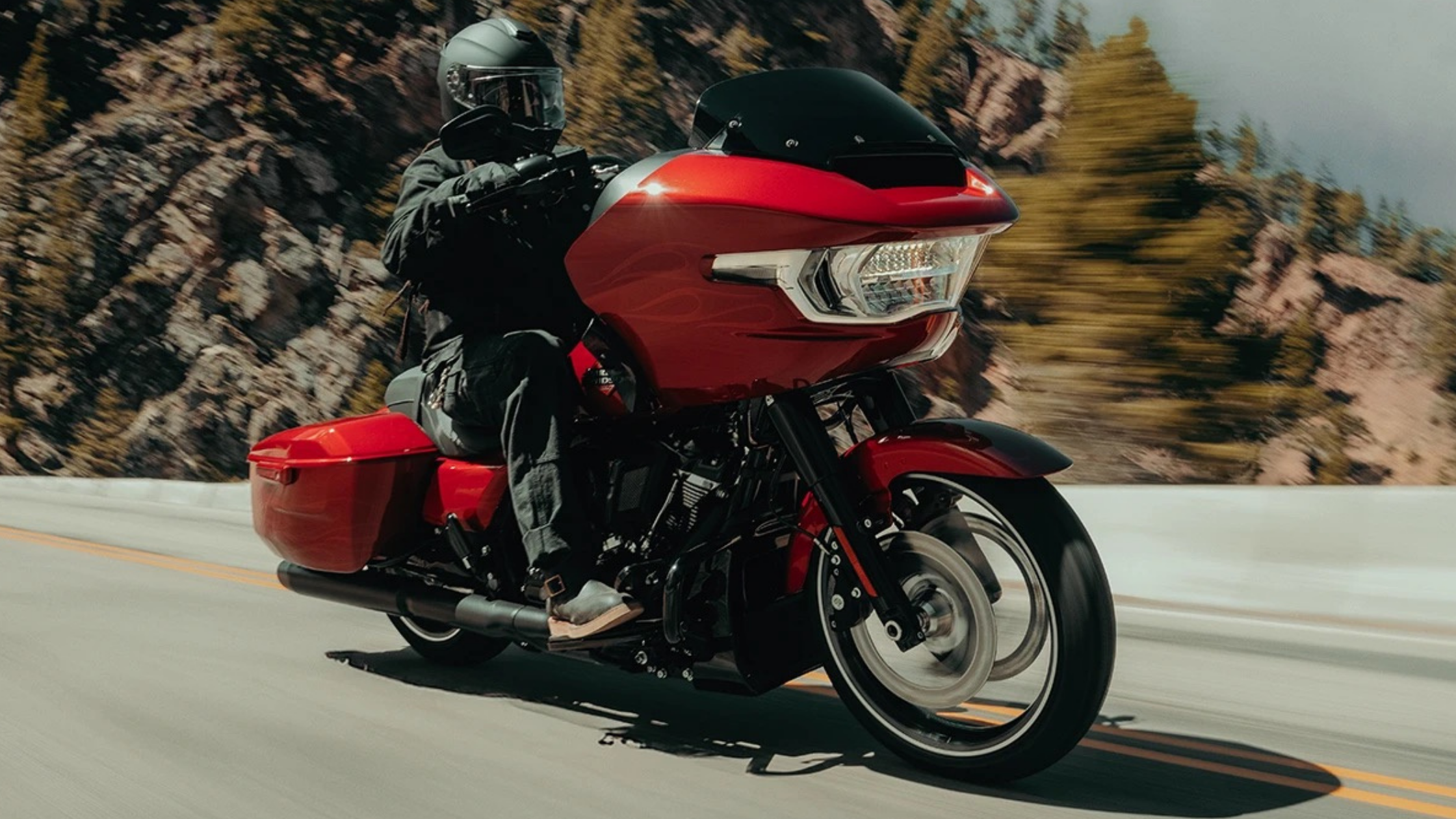 2025 Harley-Davidson Road Glide® in vibrant red on a winding mountain road.