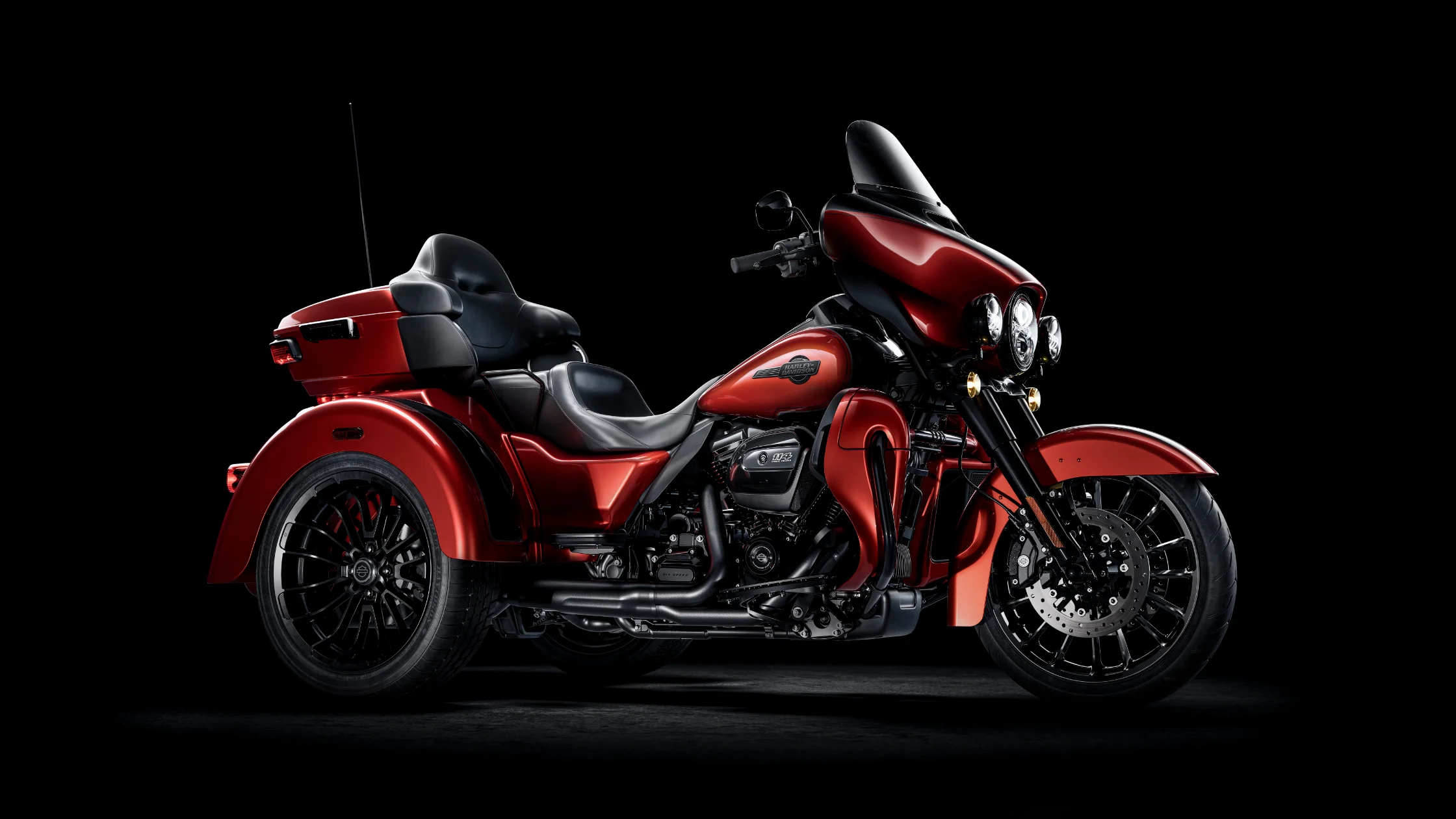 2025 Harley-Davidson Tri Glide Ultra in a striking red finish, displayed against a black background.