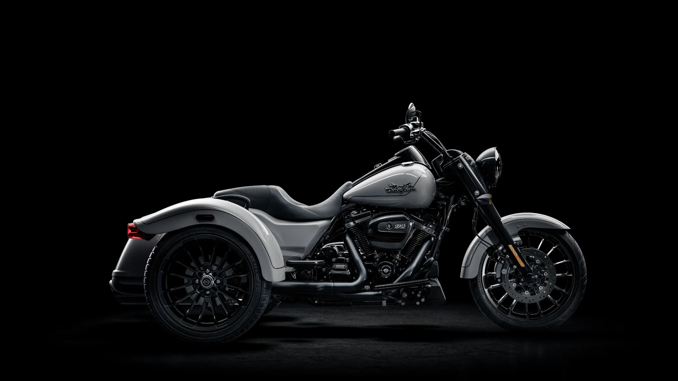 2025 Harley-Davidson Freewheeler in a sleek gray finish, displayed against a black background, highlighting its bold three-wheel cruiser design with blacked-out details and Milwaukee-Eight 114 engine.