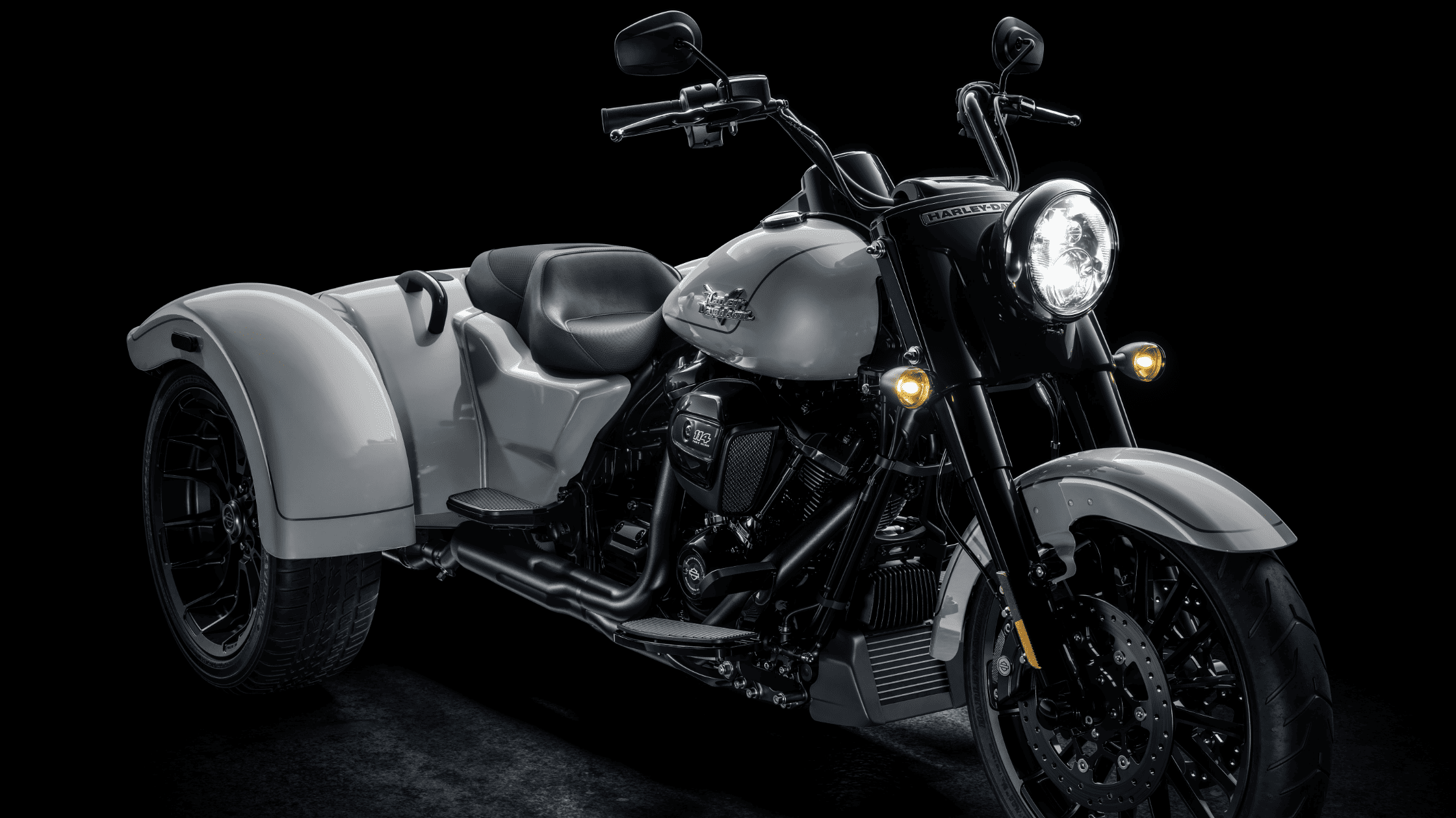 White and black trike motorcycle displayed against a dark background.
