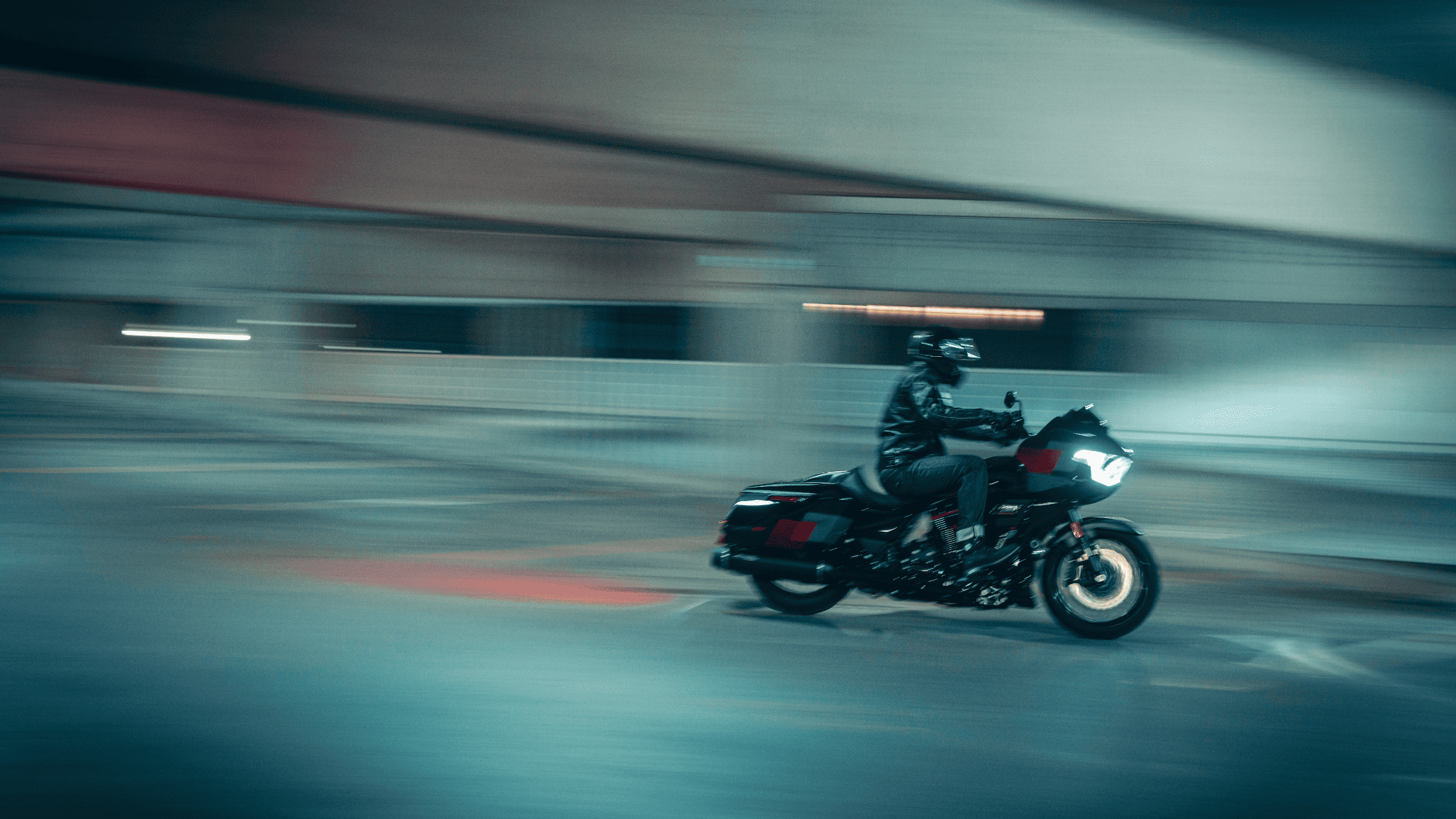 A rider on a 2025 Harley-Davidson® CVO™ Road Glide® ST speeds through an urban environment at night.