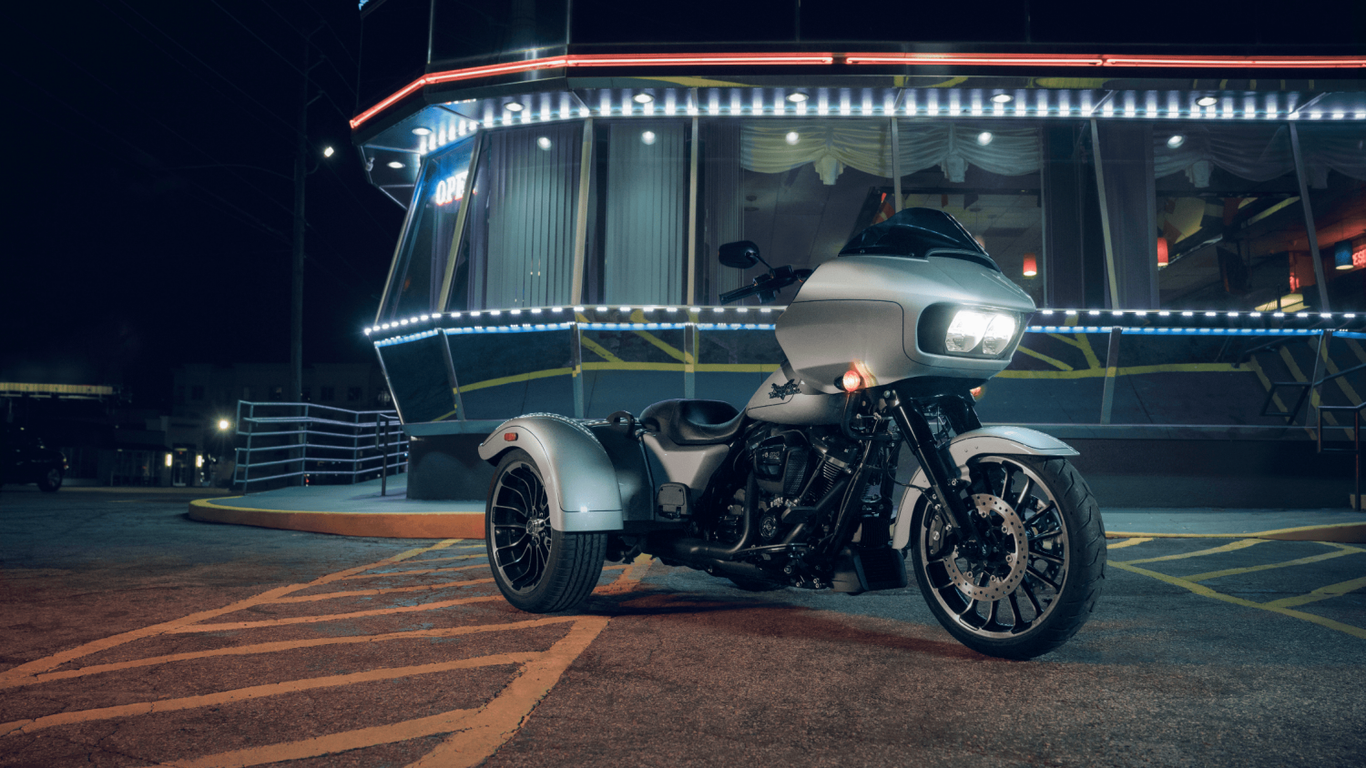 A 2025 Harley-Davidson® Road Glide® 3 parked at night outside a restaurant in Stuart, FL, showcasing its sleek design. Available at Treasure Coast Harley-Davidson®.