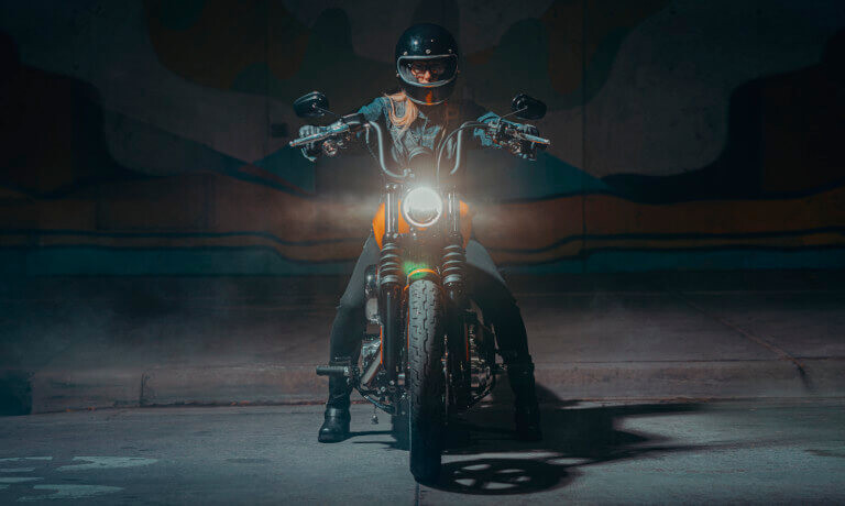 2025 Harley-Davidson Street Bob head on with a rider and headlamp