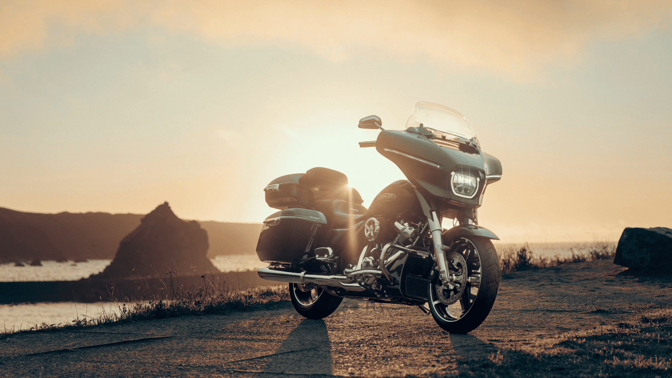 2025 Harley-Davidson® Street Glide® parked by the coast at sunset with ocean and cliffs in view